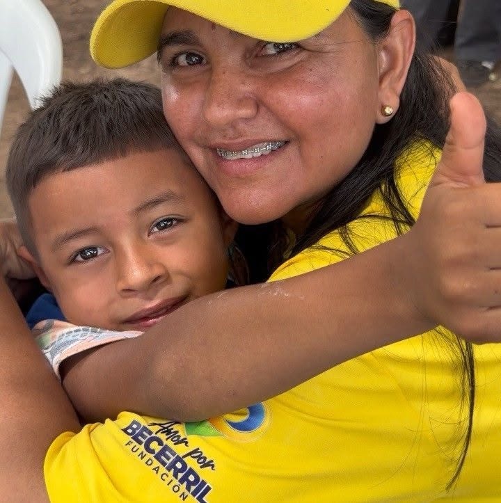Adriana Bolaño sonriendo junto a un niño